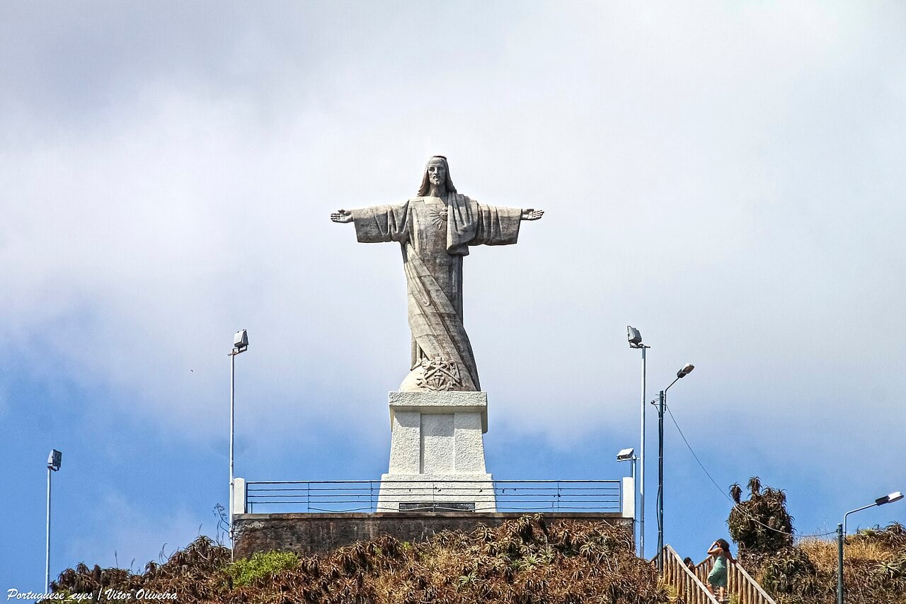The Cristo Rei statue at Garajau, seen from the front with outstretched arms above its stone pedestal.